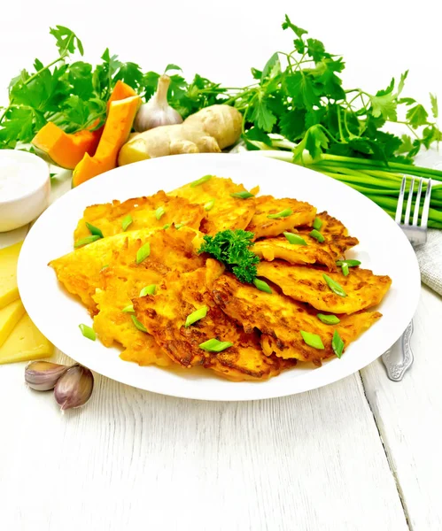 Pancakes of pumpkin with cheese in white plate on wooden board — Stock Photo, Image