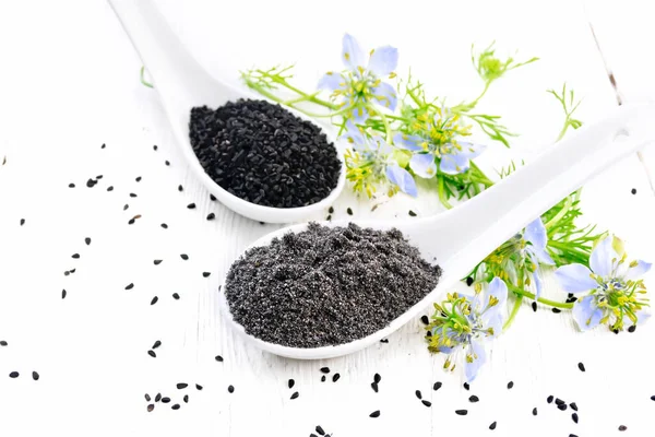 Nigella Sativa Tohumları Iki Kaşıkta Mavi Çiçekli Yeşil Yapraklı Kalingini — Stok fotoğraf