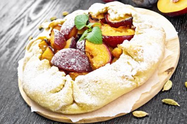 Erikli tatlı turta, kağıt üzerinde şeker ve kakule, ahşap bir arka planda yeşil nane filizleri