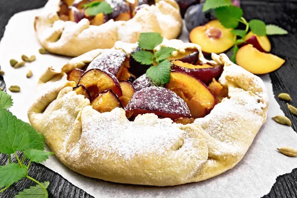 Duas Tortas Doces Com Ameixas Açúcar Cardamomo Papel Raminhos Hortelã — Fotografia de Stock