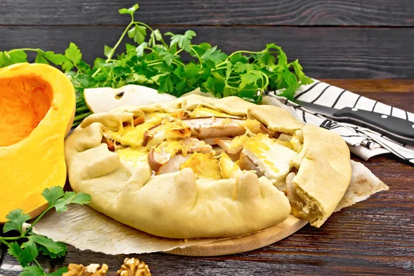 カボチャのパイ 羊皮紙に柔らかいチーズとクルミ タオルとナイフ 木の板の背景にパセリ — ストック写真