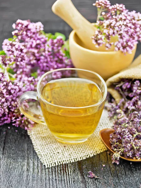 Oregano Herbal Tea Glass Cup Burlap Fresh Flowers Mortar Table Stock Image