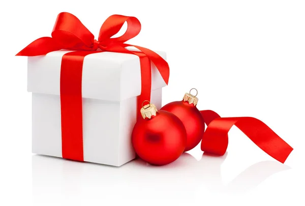 白色礼物盒系好红色丝带蝴蝶结和两个圣诞小玩意隔离在白色背景 — 图库照片