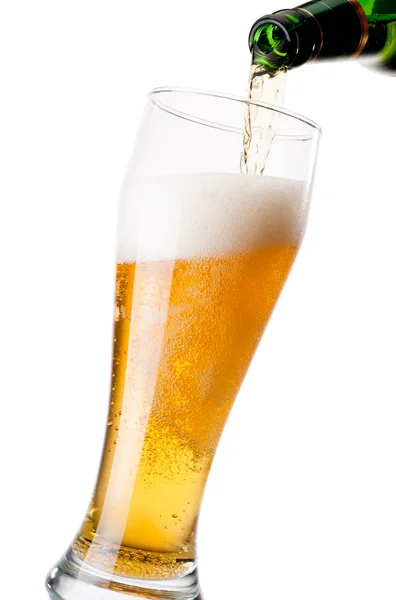 Despejando cerveja de garrafa para vidro sobre fundo branco — Fotografia de Stock