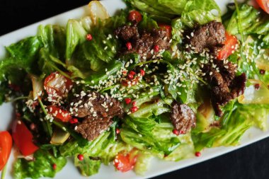 Lezzetli yemekler: yavaş pişmiş çekti sığır eti taze sebze salatası yakın bir plaka üzerinde çekim ile. Yatay üstten görünüm