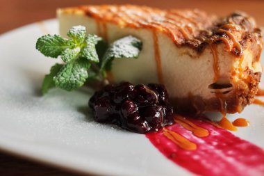 Lezzetli ve tatlı yaban mersinli cheesecake beyaz plaka üzerinde ahşap Tablo görünümü ile kopya alanı kadar yakın krem şanti ile devam eder. Kafe ve restoran veya Doğum günü pastası için ev yapımı ekmek.