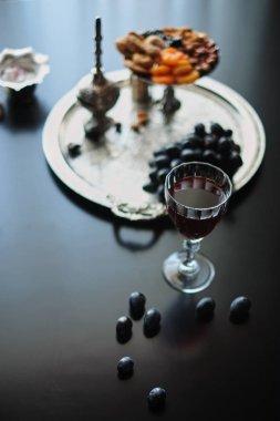 Kırmızı şarap, bardağı ceviz, üzüm ve incir koyu arka plan üzerinde