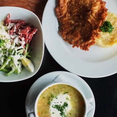 yemek masası: bir tabak çorba, risotto pirzola ve sebze salatası üstten görünüm