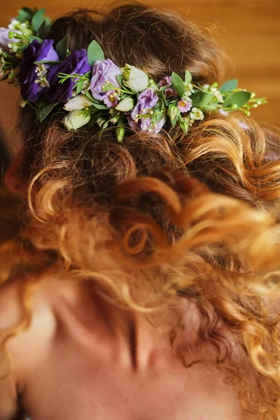 bride with red hair and wreath from flowers orange beckground