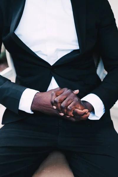 black man in a business suit sitting in a chair