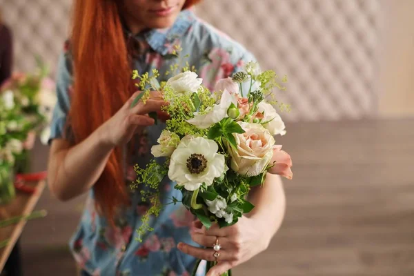 hands of florist collect wedding bouquet. florist at work