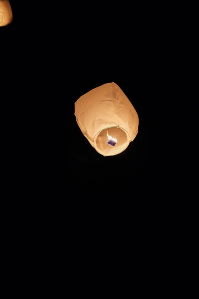 Sky lantern floating into the night sky at the festival in Pingxi, the Chinese text is a wish for money in New Year