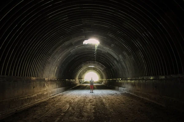 暗いトンネルで孤独なシルエットが 明るみに出てくる — ストック写真