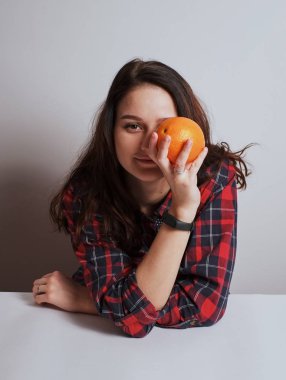 Turuncu gülümseyen kız kameraya stüdyo beyaz arka plan görünüyor