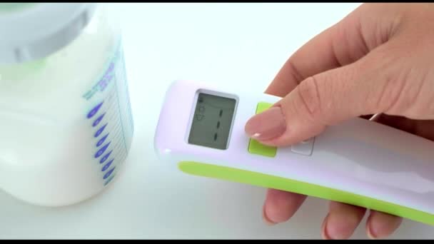 Ręce Matki Dziewczynki Zmierzyć Temperaturę Mleka Butelce Dla Dziecka Bezdotykowym — Wideo stockowe