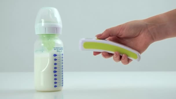 Dłonie Matki Dziewczynki Mierzą Temperaturę Mleka Butelce Dla Dziecka Bezdotykowym — Wideo stockowe