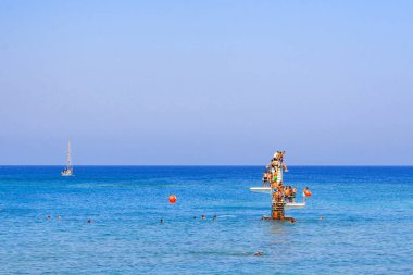 Rodos, Yunanistan, sahilinde suya atlamak isteyen insanların bir grup ile denizde dalış platformu