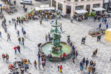 insanlar leylek Çeşmesi yakınındaki meydanın etrafında yürüyor