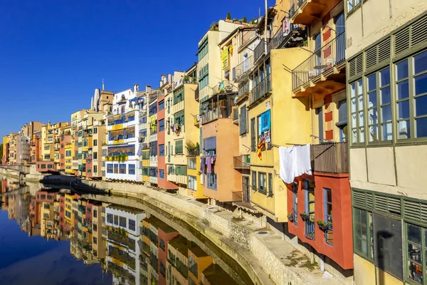 Färgglada gula och orangea hus reflekterade i vatten, Girona — Stockfoto