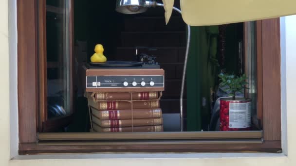Pato amarelo girando em um registro de gramofone jogado em uma plataforma giratória em livros — Vídeo de Stock