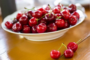 tabak dolusu kiraz ahşap bir masa üzerinde