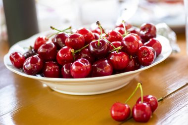 tabak dolusu kiraz ahşap bir masa üzerinde