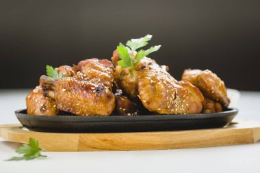 Dökme demir tabakta susamlı kızarmış tavuk kanadı.