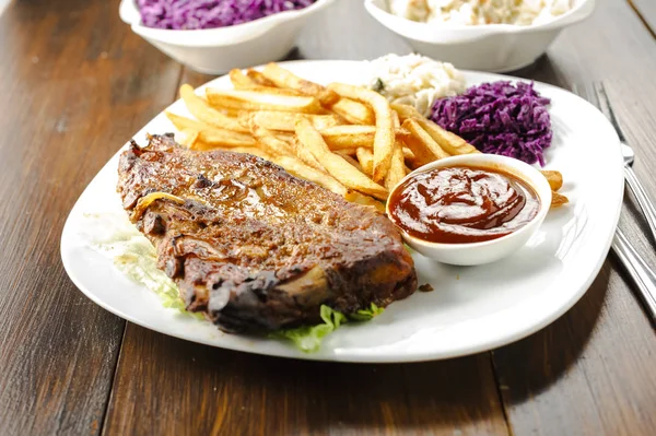 baked ribs with French fries and cabbage salad