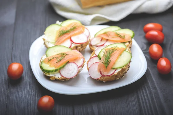 tasty breakfast - small sandwiches with salmon on vegetables