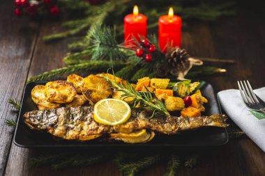 Siyah plaka üzerinde sebze ile doldurulmuş ızgara alabalık