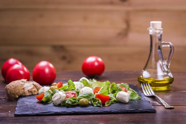 Salat Mit Mozzarella Und Tomaten Auf Einem Steinteller Serviert — Stockfoto