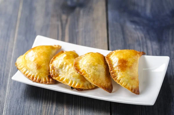 Empanada - a dish of South American cuisine - baked dumplings stuffed with meat and vegetable