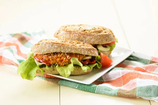 long sandwich with breaded chicken tenderloin and vegetables