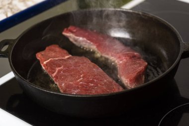 bir dökme demir tava ve bir indüksiyon Ocak sığır eti biftek kızartma