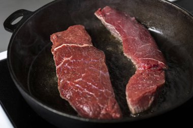 bir dökme demir tava ve bir indüksiyon Ocak sığır eti biftek kızartma