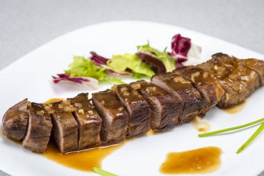 Biftek sosu beyaz tabağa döküldü.