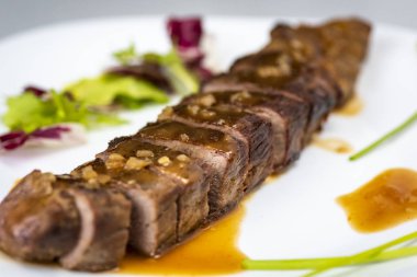 Biftek sosu beyaz tabağa döküldü.