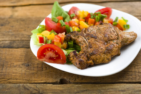 roasted pork chop with bone served with vegetables