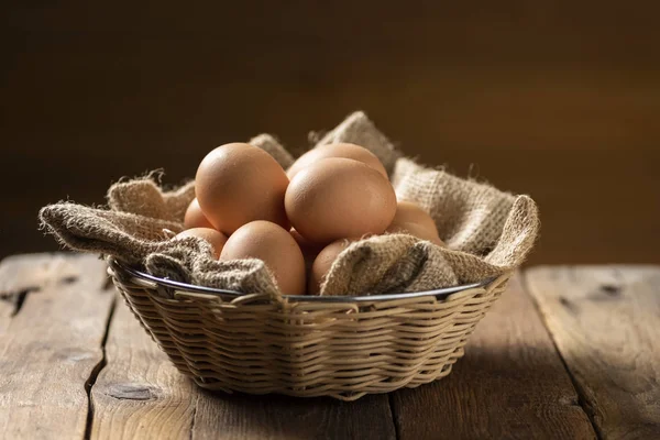 Ovos em uma cesta em uma mesa de madeira — Fotografia de Stock