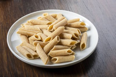beyaz plaka üzerinde makarna, kepekli penne