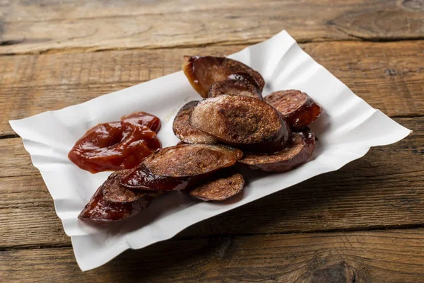 Fried sliced sausage -  dish on a paper tray — Stock Photo, Image