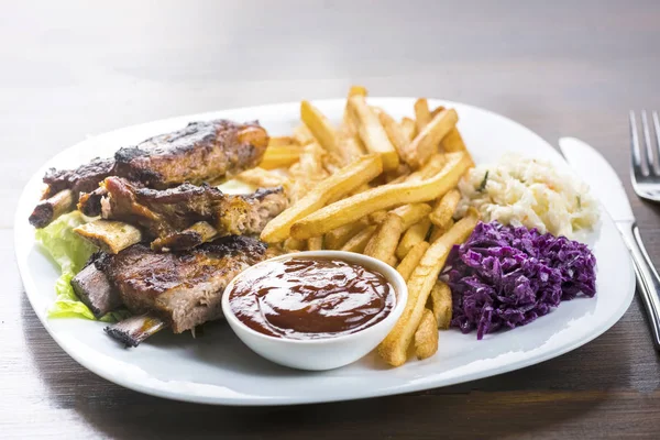 baked ribs and French fries and cabbage salad