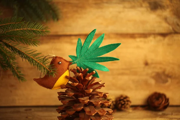 handmade toy cannabis leaf in the bird\'s beak. Cannabis marijuana new year product recreation