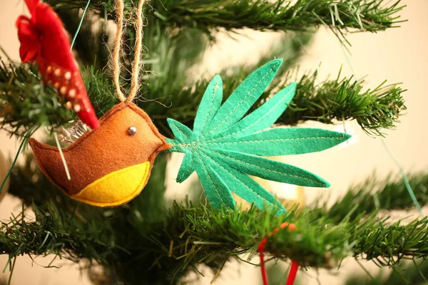 handmade toy cannabis leaf in the bird\'s beak. Cannabis marijuana new year product recreation