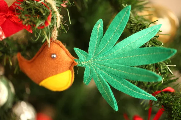 handmade toy cannabis leaf in the bird\'s beak. Cannabis marijuana new year product recreation