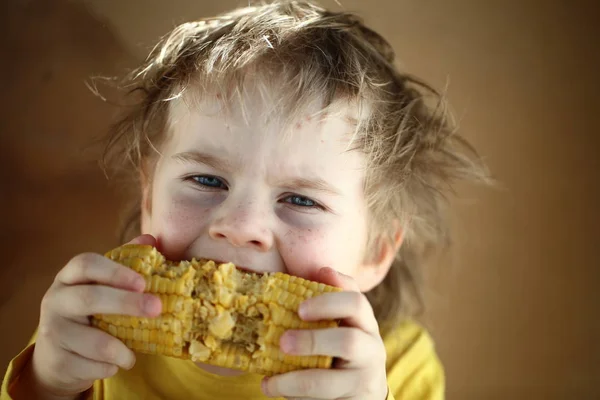 Boy eating sweet corn