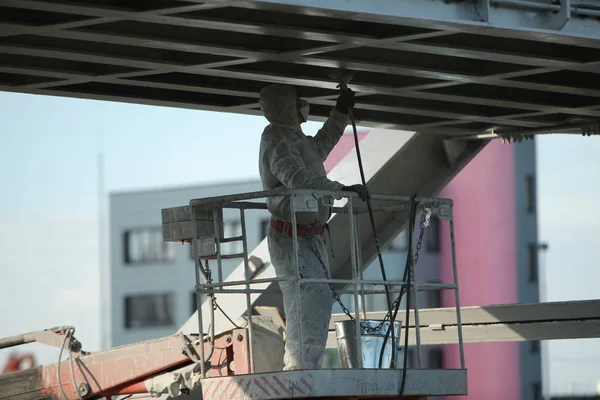 worker painting bridge, repair concept