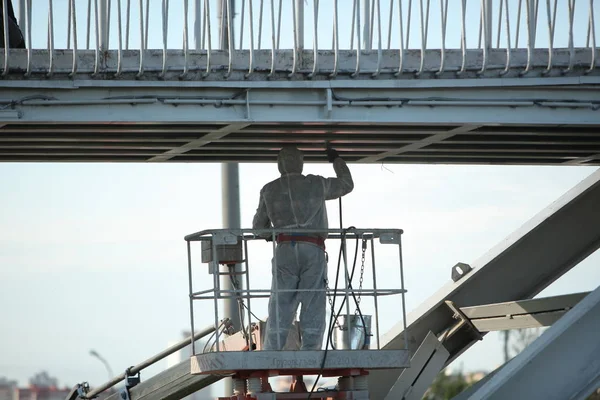 worker painting bridge, repair concept