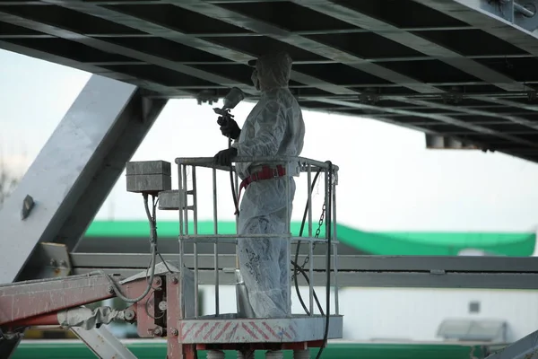 worker painting bridge, repair concept