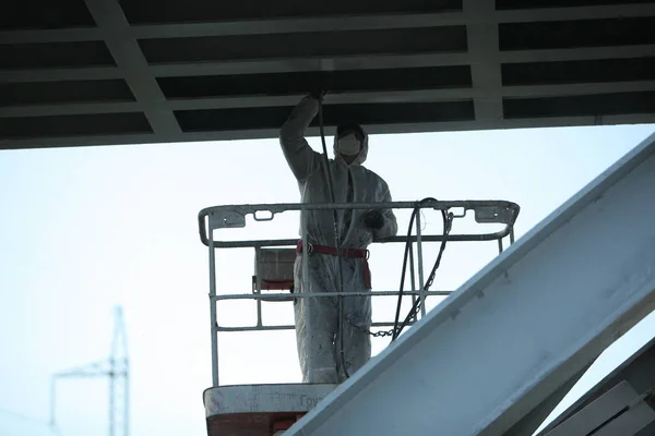 worker painting bridge, repair concept